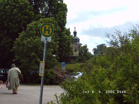 Hier ragt ein Turm des kleinen Schlosses durchs Grün